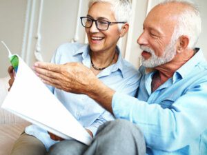 A senior couple smiling as they look over their retirement plan.